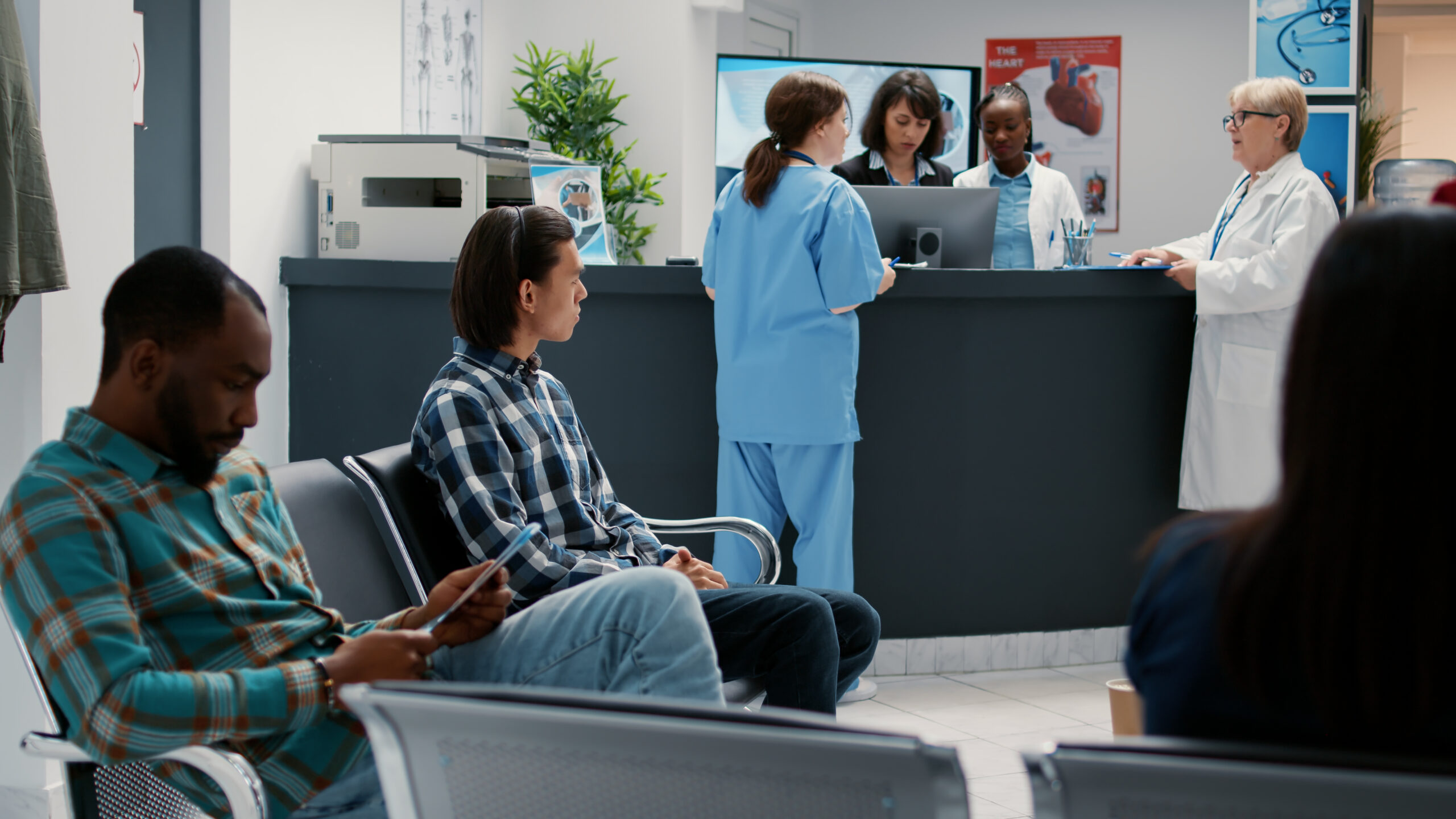 Pacientes aguardando atendimento em hospital com recepção movimentada, ilustrando a situação de descredenciamento de hospitais e clínicas pelo plano de saúde e os direitos dos consumidores.