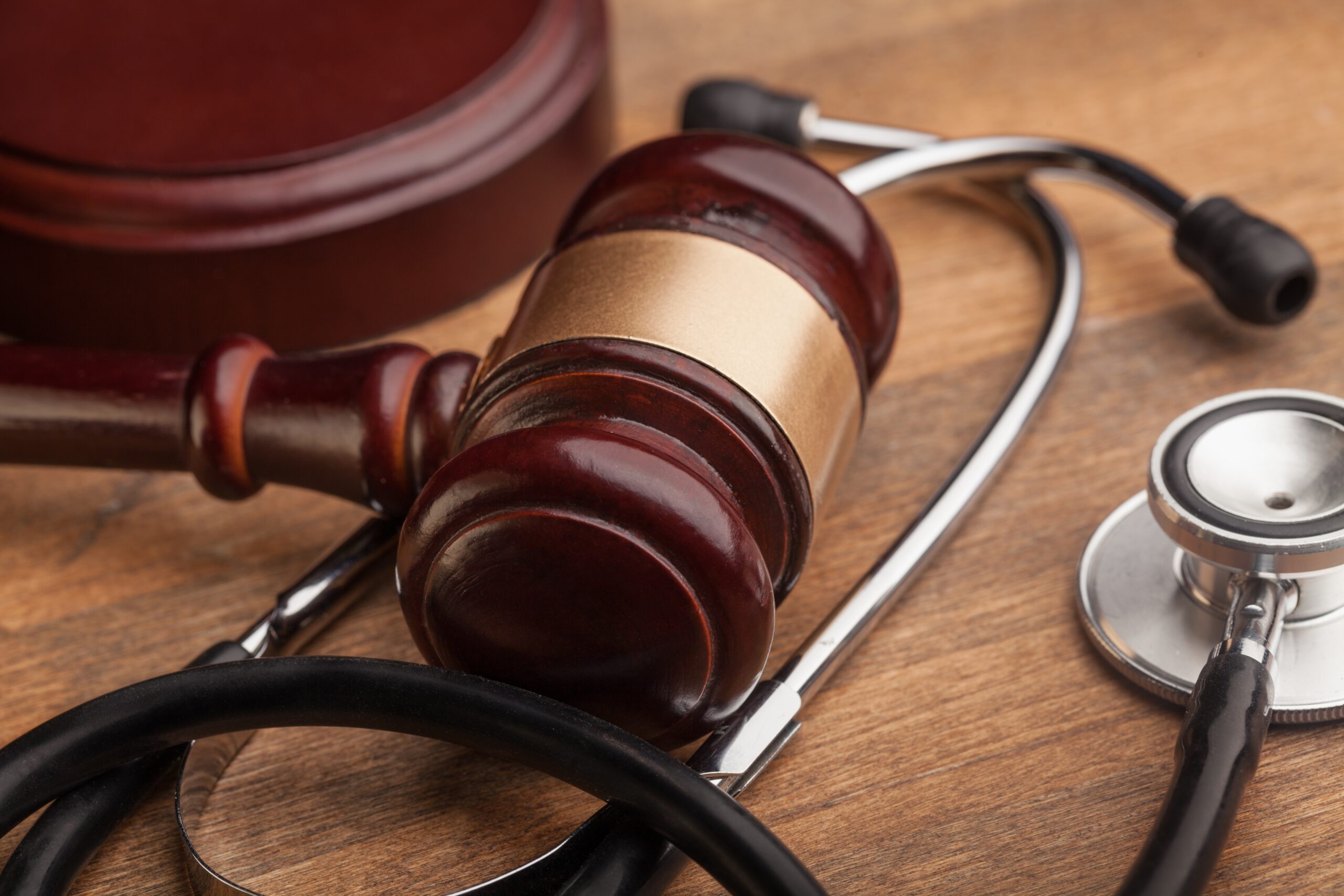 Martelo da justiça ao lado de estetoscópio, representando decisões liminares para garantir cirurgia ou medicamento negado pelo plano de saúde.