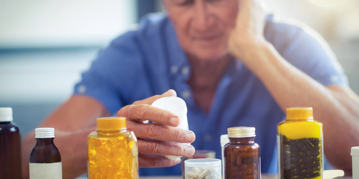 Paciente com Esclerose Múltipla aguardando medicamentos de alto custo em farmácia do SUS, evidenciando o impacto do desabastecimento na saúde pública.