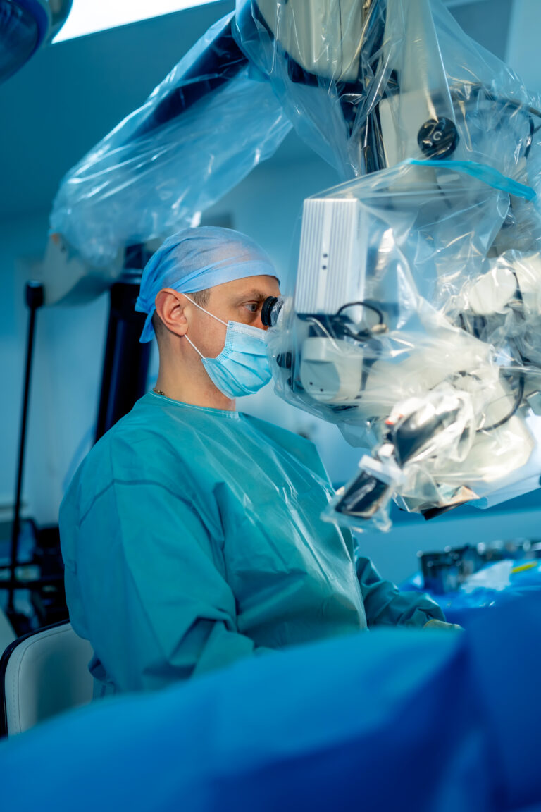 Cirurgião realizando cirurgia retroperitoneal robótica com auxílio de microscópio, ilustrando procedimentos de alta precisão em ambiente cirúrgico moderno.