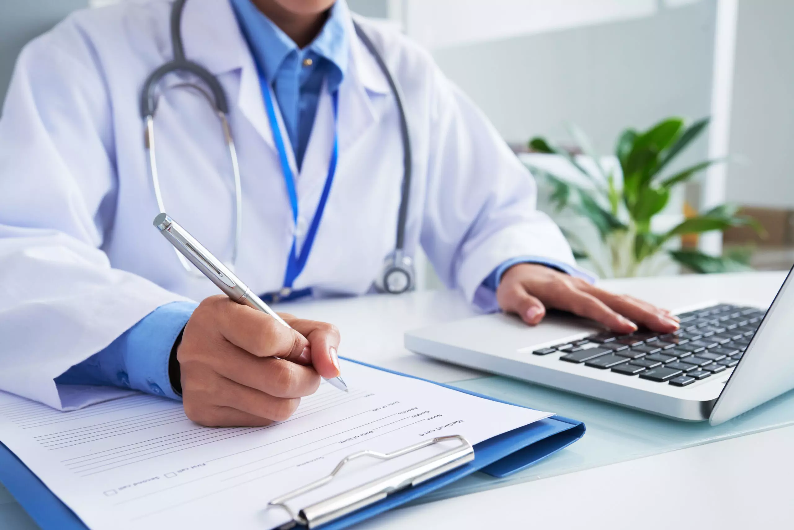 AnyConv.com hands unrecognizable female doctor writing form typing laptop keyboard scaled 1